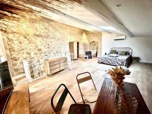 a living room with a bed and a stone wall at Maison en pierre avec piscine, 6 couchages, située au cœur de Mallemort, Provence. - FR-1-658-25 in Mallemort +18 photos