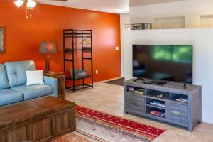 a living room with a couch and a tv at Carnelian Coyote - Fabulous Condo in West Sedona! in Sedona