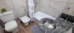 a bathroom with a toilet and a sink and a toilet at JUJUY SOHO in San Salvador de Jujuy +53 photos