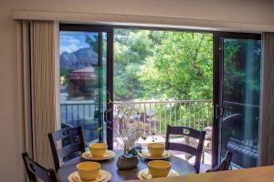 a table with yellow cups and saucers on top of a balcony at Carnelian Coyote - Fabulous Condo in West Sedona! in Sedona
