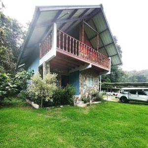 een huis met een balkon op een tuin bij Bambito Hosting in Bambito