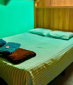 Una cama con manta y almohadas. en Bambito Hosting, en Bambito