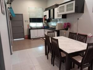 a kitchen and dining room with a table and chairs at Amara Homestay Kuantan in Kampong Bugis