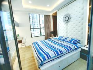 a bedroom with a bed with blue and white sheets at Linda Apartment-ICON56-District4-3mins to center dtrc1- INFINITY POOL- AWESOME ROOFTOP in Ho Chi Minh City