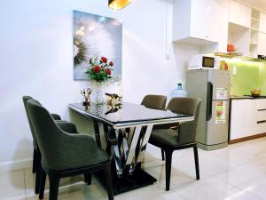 a dining room table with chairs and a refrigerator at Linda Apartment-ICON56-District4-3mins to center dtrc1- INFINITY POOL- AWESOME ROOFTOP in Ho Chi Minh City