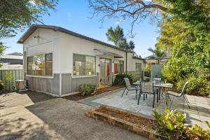 a house with a patio and a table and chairs at Kingston Gardens by Experience Jervis Bay in Huskisson