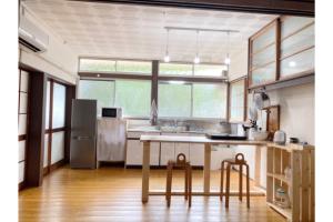 una cocina con mesa y algunas sillas. en awa guesthouse, en Tateyama