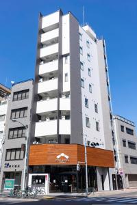 un edificio blanco alto en una calle de la ciudad en COB HOTEL Asakusa, en Tokio