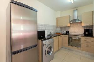 cocina con nevera de acero inoxidable y lavadora en Lovely Bedroom in shared apartment Oroklini, en Oroklini