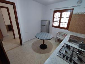 a kitchen with a table and a sink and a stove at Calm place and near to the beach in Monastir