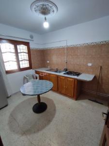 a kitchen with a table in the middle of a room at Calm place and near to the beach in Monastir