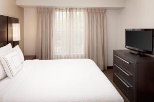 um quarto de hotel com uma cama e uma televisão de ecrã plano em Residence Inn Arlington em Arlington