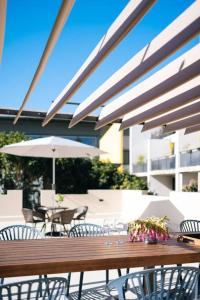 シドニーにあるOnceUp A BlueMoon Terrace nr CBDの木製テーブル(椅子、傘付)