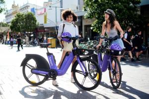 シドニーにあるOnceUp A BlueMoon Terrace nr CBDの二人の女性が紫の自転車の横に立っている