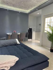 Una gran cama azul en una habitación con cocina en Departamento por plaza terraza oblatos en Guadalajara