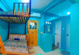 niebieski pokój z łóżkiem piętrowym i drzwiami w obiekcie SmallFry's Beach Resort w mieście Calatrava