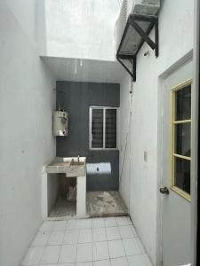 La salle de bains blanche est pourvue d'un lavabo et d'une fenêtre. dans l'établissement Departamento por plaza terraza oblatos, à Guadalajara