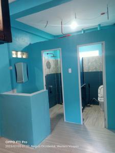 La salle de bains est pourvue de toilettes et d'un mur bleu. dans l'établissement SmallFry's Beach Resort, à Calatrava