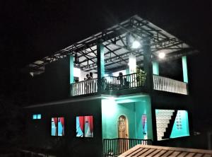 a building with people on the balcony at night at SmallFry's Beach Resort in Calatrava