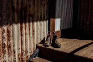a pair of boots sitting on a step next to a building at Bamurru Plains in Point Stuart