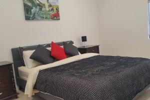 a bedroom with a bed with black and red pillows at 3 BDR Townhouse 200m from station 4 beds in Melbourne