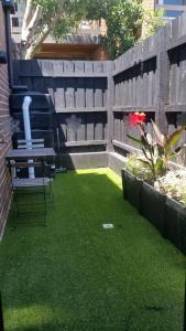 a patio with a table and a chair on the grass at 3 BDR Townhouse 200m from station 4 beds in Melbourne