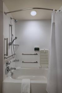 y baño blanco con bañera y ducha. en Courtyard St. Louis Brentwood, en Richmond Heights