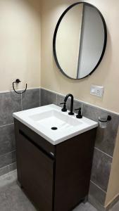 a bathroom with a sink and a mirror at Las Rejas Departamento in San Fernando del Valle de Catamarca