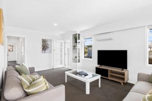 sala de estar con sofá y TV de pantalla plana en Idyllic family escape, Close to the beach and Mount, en Mount Maunganui