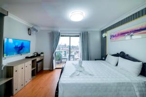 a bedroom with a large bed and a television at Hanoi Sofia Hotel in Hanoi