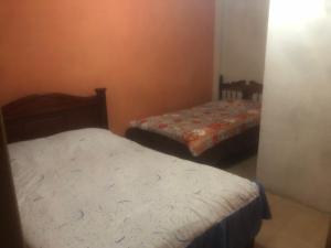 a room with two beds in a room at Pensión Malacatos in Loja