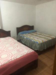 Habitación con 2 camas en una habitación en Pensión Malacatos, en Loja