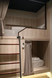 2 Etagenbetten mit einer Leiter in einem Zimmer in der Unterkunft Jincheng Hostel in Changhua County