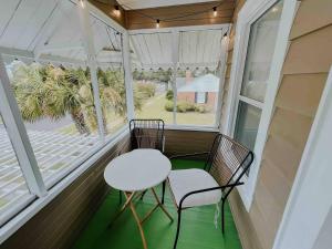 a porch with two chairs and a table and two windows at The Historique - Charming 1BR Near Historic Downtown in Panama City