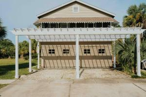 a garage with a white pergola in front of a house at The Historique - Charming 1BR Near Historic Downtown in Panama City