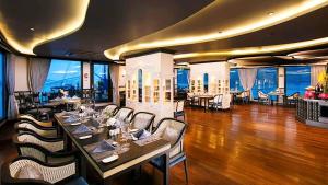 a restaurant with tables and chairs and a view of the ocean at Lotus Elegance Cruise in Ha Long