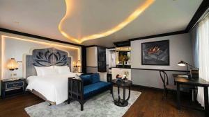 a bedroom with a bed and a chair and a desk at Lotus Elegance Cruise in Ha Long