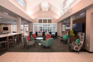 duży hol ze stołami i krzesłami oraz kawiarnią w obiekcie Residence Inn by Marriott Arlington South w mieście Arlington
