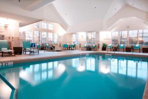 a pool in a hotel with chairs and tables at Residence Inn by Marriott Arlington South in Arlington