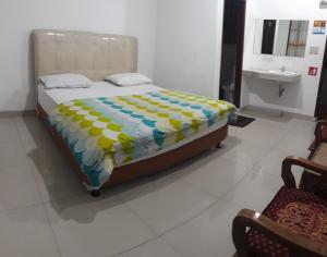 una camera con un letto e un piumone giallo e blu di WISMA SIBAYAK Guesthouse BERASTAGI a Berastagi