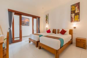 - une chambre avec 2 lits et une fenêtre dans l'établissement Frangipani House and Spa by ecommerceloka, à Canggu