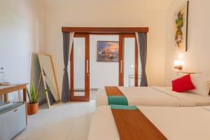 una habitación de hotel con dos camas en una habitación en Frangipani House and Spa by ecommerceloka, en Canggu