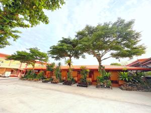 Khong Chiam Hotel في خونغ شيام: صف من النباتات أمام مبنى