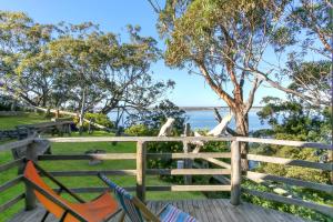 a hammock on a fence with a view of the water at Jetty Road Retreat in Nungurner