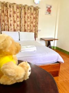 a teddy bear sitting at a table in a hotel room at Khong Chiam Hotel in Khong Chiam +7 photos
