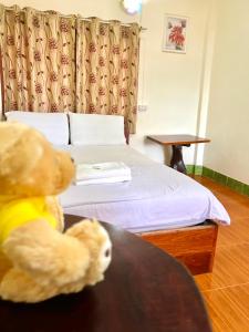 a teddy bear sitting at a table in a hotel room at Khong Chiam Hotel in Khong Chiam