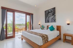 Un dormitorio con una cama y un balcón. en Frangipani House and Spa by ecommerceloka, en Canggu