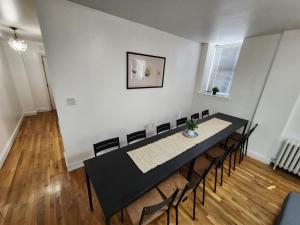 a dining room with a black table and chairs at Spacious 3 bedroom apartment mins to NYC! in Union City