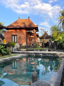a house with a swimming pool in front of a house at Villa Miracle Ubud in Ubud