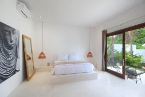 Modern and stylish 3 Bedroom Villa في أوبود: غرفة نوم بها سرير ونافذة كبيرة +23 صورة